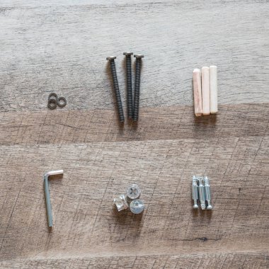 Üstten görünüm düzenleme grubu için araya hazır ahşap mobilya montaj kopya alanı ile vintage ashwood gemide parçalar (dübel, cıvata, çamaşır makinesi, allen anahtarı, vida). DIY konsepti için aletleri.
