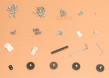 Yakın çekim üstten görünüm araçları karton bir arka plan üzerinde mobilya montaj için. Parçalar, vida somunlar düzenleme grubu. Dübel, cıvata, çamaşır makinesi, Allen anahtarı, vida için araya hazır ahşap