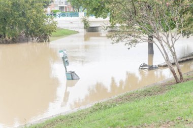Yüksek su ile Köprüsü yakınlarında yol, atık İstasyonu ve açık çelik çöp receptacle gömülmek altında su bastı. Ağır yağış banliyö Dallas Fort Worth, Teksas, ABD