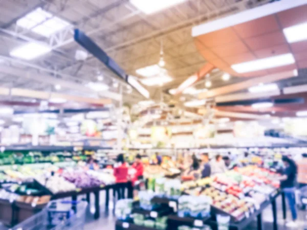 Blurred motion busy customer shopping for fresh fruits and vegetables at grocery store in Irving, Texas, US. Organic, locally grown produces on display. Healthy food abstract background in supermarket