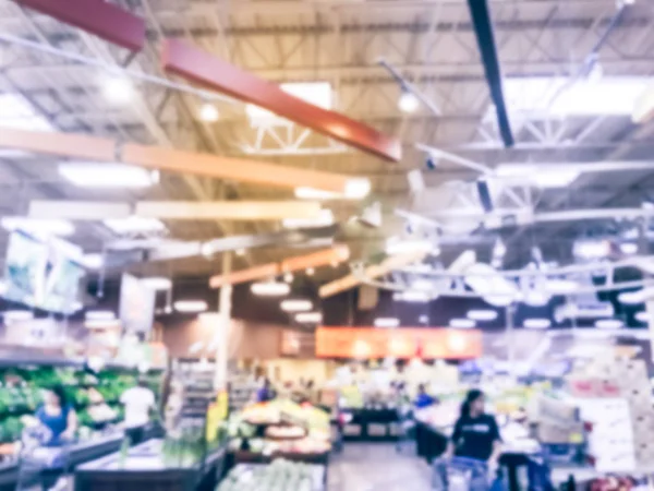 Blurred motion busy customer shopping for fresh fruits and vegetables at grocery store in Irving, Texas, US. Organic, locally grown produces on display. Healthy food abstract background in supermarket