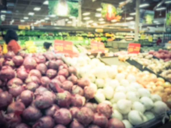 Vintage tone blurred customer shopping for fresh fruits and vegetables at grocery store in Irving, Texas, US. Organic, locally grown produces on display. Healthy food abstract background supermarket