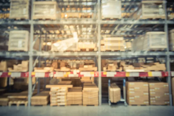 Blurred full-frame image aisles and bins at furniture warehouse in America. Defocused abstract industrial storehouse interior full of boxes, shelves, racks from floor to ceiling
