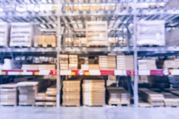 Blurred full-frame image aisles and bins at furniture warehouse in America. Defocused abstract industrial storehouse interior full of boxes, shelves, racks from floor to ceiling