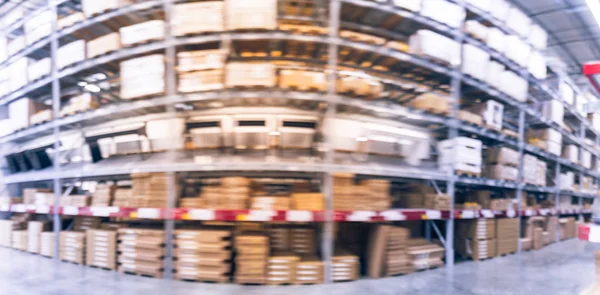 Panorama view blurred full-frame image aisles and bins at furniture warehouse in America. Defocused abstract industrial storehouse interior full of boxes, shelves, racks from floor to ceiling