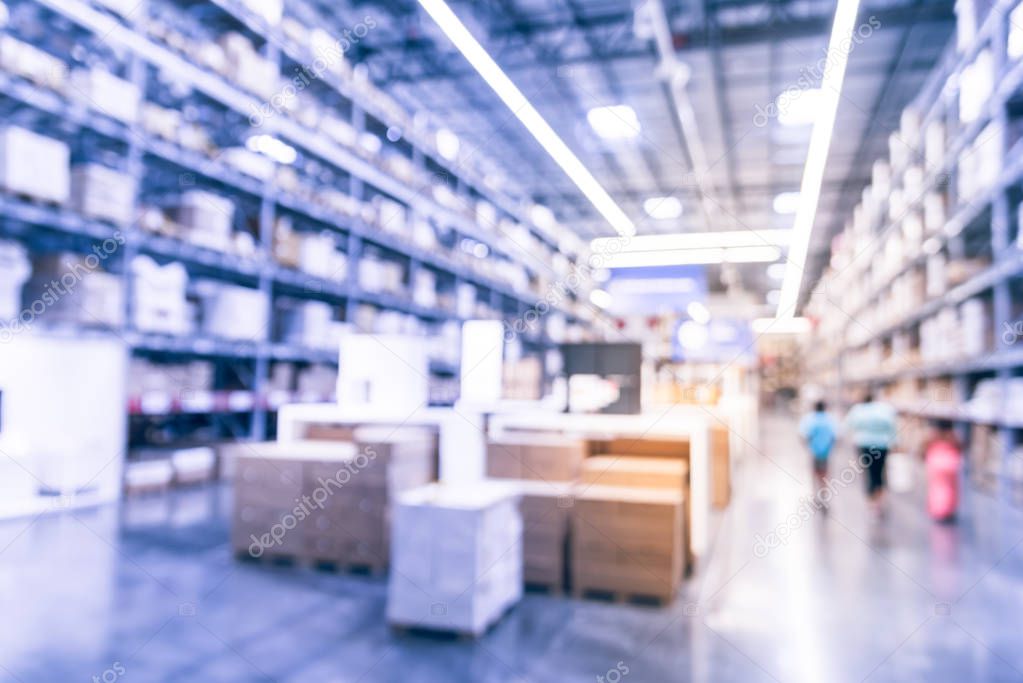 Vintage tone abstract blurred customer shopping at large furniture warehouse in Texas, America. Defocused interior storehouse full of boxes, row of aisles, bins, shelves, racks floor to ceiling