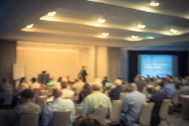 Sahne Alanı'nda bulanık iş Seminer Toplantı ile Led projektör ekran ve hoparlör konuşma. Konferans salonu salonundaki arka görünümün hedef kitlesi ABD'de talk-show dinleme defocused. Eğitim, iş kavramı