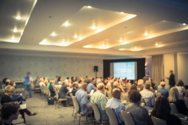 Sahne Alanı'nda bulanık iş Seminer Toplantı ile Led projektör ekran ve hoparlör konuşma. Konferans salonu salonundaki arka görünümün hedef kitlesi ABD'de talk-show dinleme defocused. Eğitim, iş kavramı