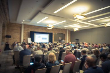 Vintage sesi iş Seminer Toplantı ile Led projektör perde, sahne alanı'nda konuşmacı konuşma bulanık. Konferans Salonu Oda, dinleme talk-show dikiz seyirci defocused. Eğitim, iş kavramı