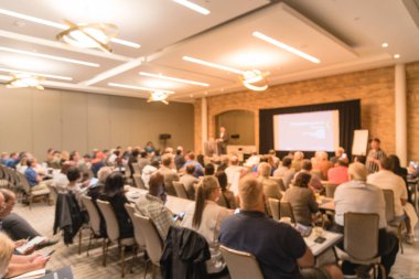 Sahne Alanı'nda bulanık iş Seminer Toplantı ile Led projektör ekran ve hoparlör konuşma. Konferans salonu salonundaki arka görünümün hedef kitlesi ABD'de talk-show dinleme defocused. Eğitim, iş kavramı