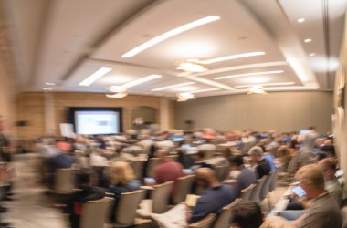 Panorama görünüm iş Seminer Toplantı ile Led projektör perde, sahne alanı'nda konuşmacı konuşma bulanık. Konferans Salonu, talk-show dinleme arka görünümün hedef kitlesi defocused. Eğitim, iş kavramı