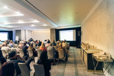 Vintage sesi iş Seminer Toplantı ile Led projektör perde, sahne alanı'nda konuşmacı konuşma bulanık. Konferans Salonu Oda, dinleme talk-show dikiz seyirci defocused. Eğitim, iş kavramı