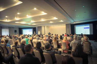 Vintage sesi iş Seminer Toplantı ile Led projektör perde, sahne alanı'nda konuşmacı konuşma bulanık. Konferans Salonu Oda, dinleme talk-show dikiz seyirci defocused. Eğitim, iş kavramı