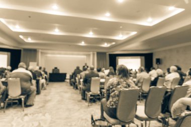 Vintage sesi iş Seminer Toplantı ile Led projektör perde, sahne alanı'nda konuşmacı konuşma bulanık. Konferans Salonu Oda, dinleme talk-show dikiz seyirci defocused. Eğitim, iş kavramı