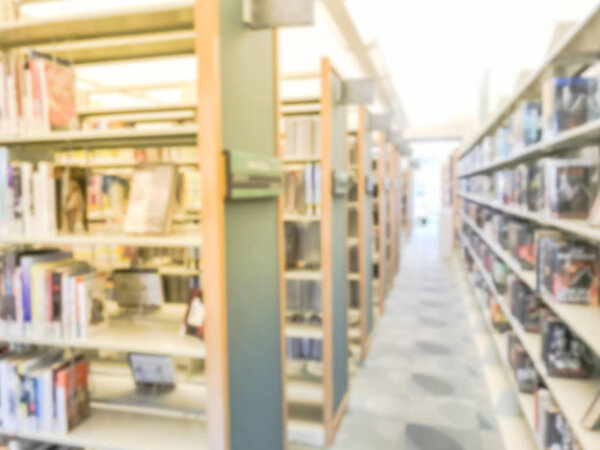 Motion blurred aisle and row of bookshelf at public library in Texas, America. Continuing education concept.