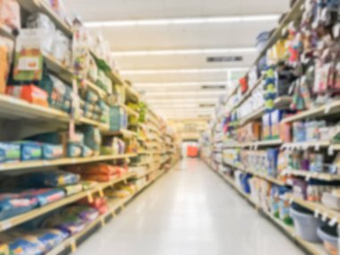 Bulanık köpek ve kedi yiyecek raflar Amerikan süpermarkette soyut. Evde beslenen hayvan levazım, çamaşır, bulaşık deterjanı, kedi kumu, evde beslenen hayvan ve fiyat etiketleri ile evde bakım koridor satır ekran defocused.