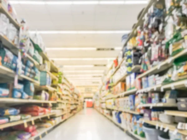 Blurred abstract low angle view dog and cat food shelves at American supermarket. Defocused pet supplies, laundry, dish soap, cat litter, pet and home care aisle row display with price tags