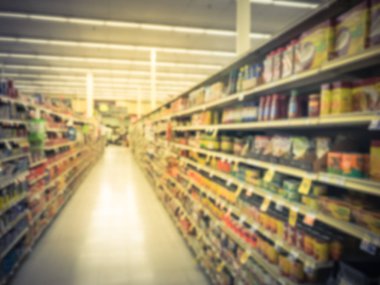 Bulanık soyut yemekler ve süpermarkette fasulye konserve. Turşu, zeytin, konserve et, çeşniler, makarna sosu, salata sosu ve konserve sebze, et, kümes hayvanları ve deniz ürünleri çok çeşitli