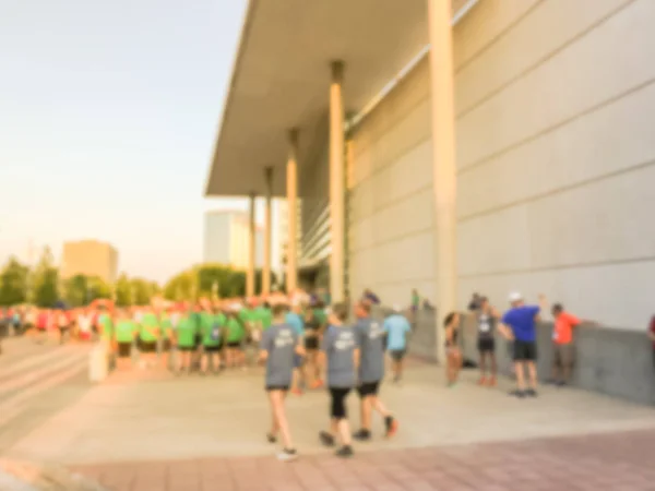 Blurred abstract group runners of all abilities of 5K running race in Richardson, Texas, US. Defocused athletes crowd ready to run. Urban sport event and fitness, wellbeing, healthy lifestyle concept