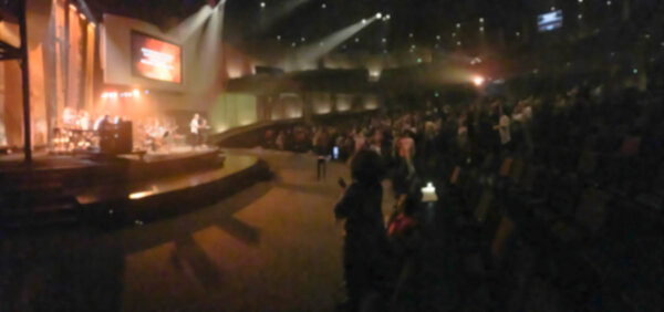 Panorama view blurry abstract worship band and the choir at Bible Church in Texas, USA. Dark background, smoke, concert spotlights for Christian concept. Worship lyric projection