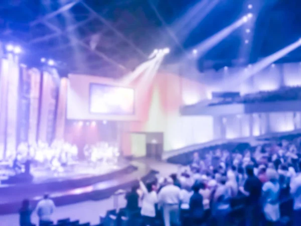 Abstract blurred Christians raising their hands in praise and worship at a night music concert with lyric projection. Eucharist therapy bless god helping repent catholic Easter lent mind pray.