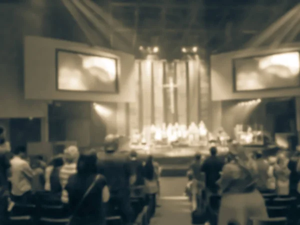 Vintage tone blurred congregation group of people assembled for live religious worship music in Texas, America. Crowd at music concert light background illumination