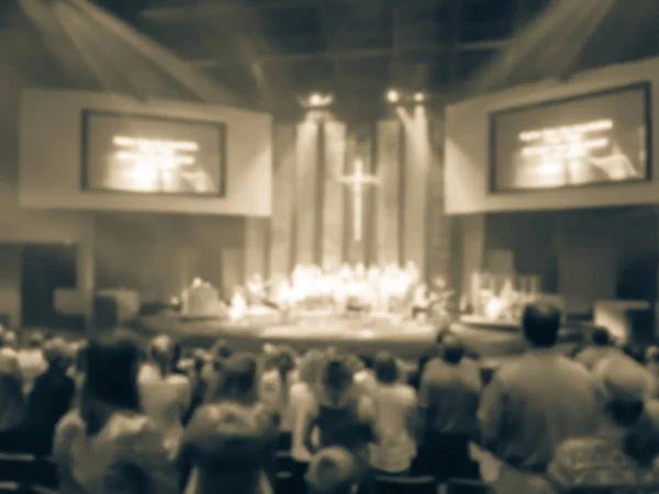 Vintage tone blurred congregation group of people assembled for live religious worship music in Texas, America. Crowd at music concert light background illumination