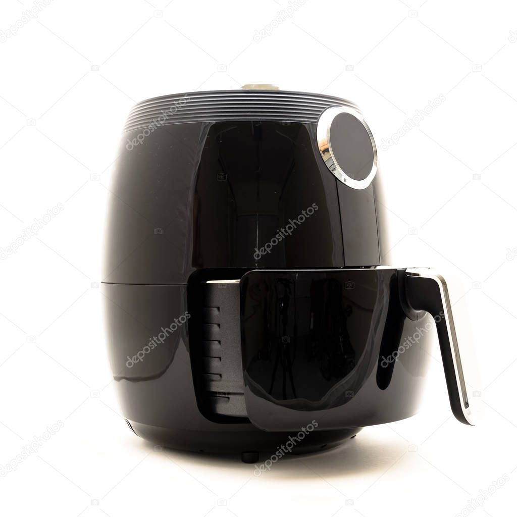 Studio shot of digital air fryer with open non-stick basket handle isolated on white background