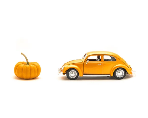 スタジオ オレンジのおもちゃの車 ミニかぼちゃの分離ホワイト バック グラウンド 小さな金属モデル車を撮影します ハロウィーン楽しいコンセプト — ストック写真