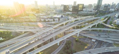 Panorama Hava eyaletler arası I-610 otoyol büyük kavşak ve Houston midtown silüetini arka plan. Değişim, yükseltilmiş yol Kavşağı Üstgeçit viyadük yığını. Her gece derecesi görünümü metropol