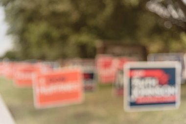 Blurred image row of yard sign at residential street for primary election day in Dallas county, Texas, USA. Signs greeting early voters, political party posters for the midterm election concept clipart