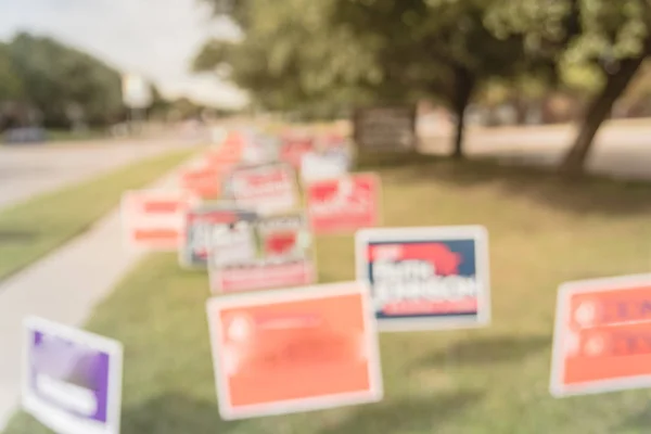 Blurred image row of yard sign at residential street for primary election day in Dallas county, Texas, USA. Signs greeting early voters, political party posters for the midterm election concept