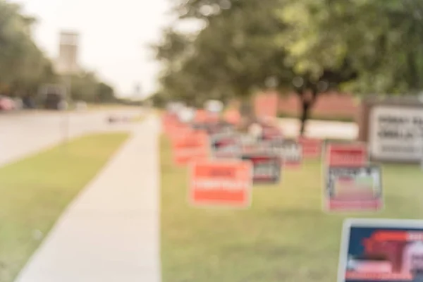 Blurred image row of yard sign at residential street for primary election day in Dallas county, Texas, USA. Signs greeting early voters, political party posters for the midterm election concept