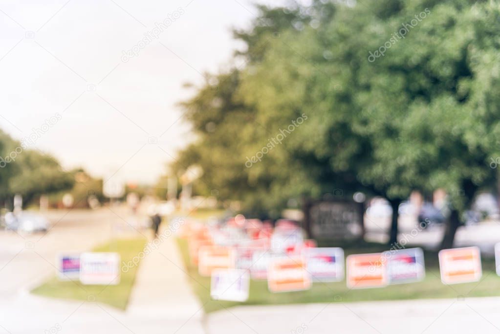 Vintage tone motion blurred people walking on residential street near yard sign at for primary election day in Dallas, Texas, USA. Signs greeting early voters.