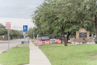 IRVING, TX, USA-OCT 22, 2018:Row of yard sign at residential street for primary election day in Dallas county, Texas, USA. Signs greeting early voters, political party posters for the midterm election clipart