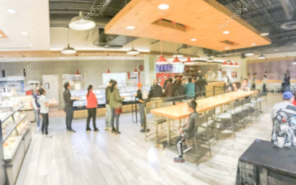 Panorama view Asian bakery shop in Texas, USA. Defocused multiethnic people waiting in line to check-out fresh baked bread in pastry shop counter.