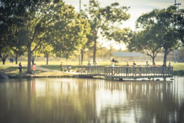 Hareket aile göl gölet açık ahşap iskele/dock yakınındaki Balık tutma çocuklar ile bulanık. Ücretsiz topluluk olay mahalle Birliği tarafından sponsor oldu. Ufuk insanlar kentsel park lakeside adlı Balık tutma