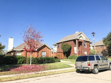 Tipik dış tek müstakil konut ev banliyö Dallas-Fort Worth Caddesi üzerinde park edilmiş araba ile içinde. Sonbahar sonbahar yaprakları parlak kırmızı akçaağaç rengi Texas, Amerika ile.