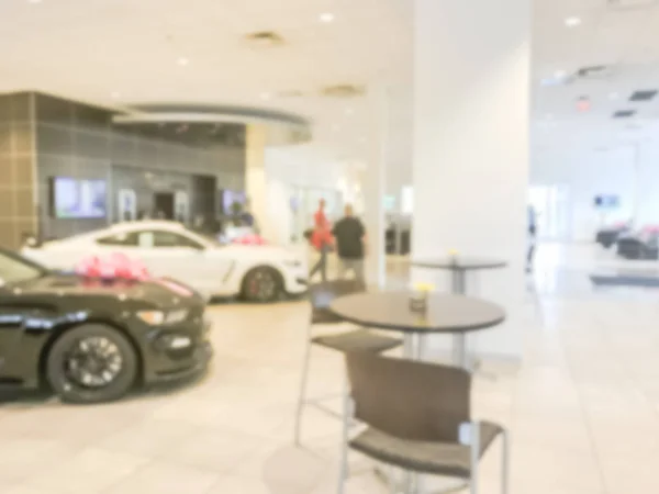 Blurred abstract inside car dealership with brand new cars and bow. Defocused car showroom in Texas, America