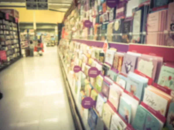 Motion blurred customer shopping, selecting greeting cards at grocery store in Texas, America.