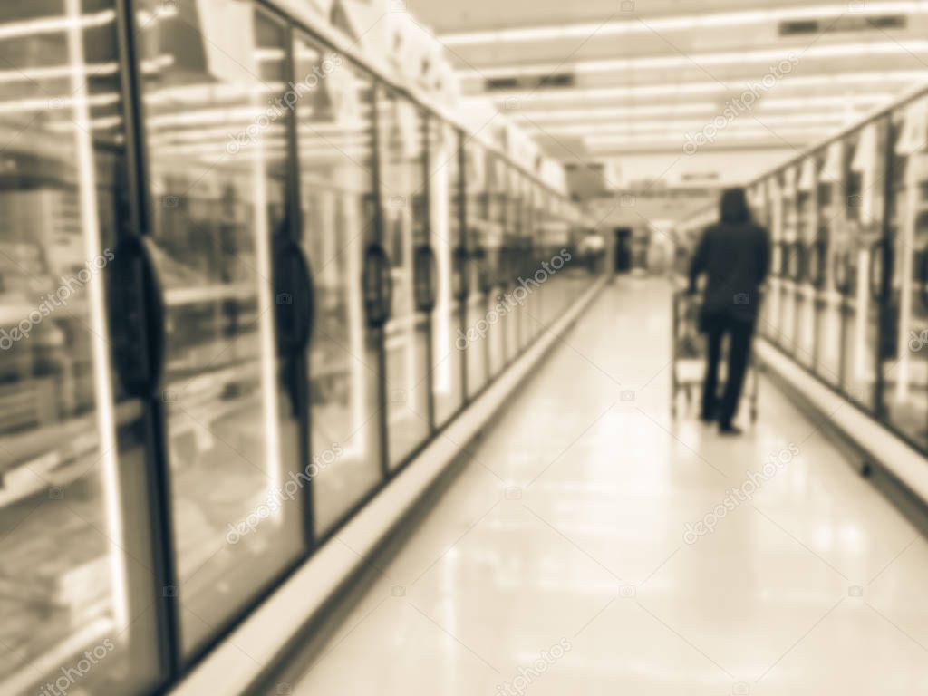 Vintage tone blurred customer shopping for frozen foods at retail store in US. Defocused huge glass door aisle with variety pack of processed fruit, vegetable, breakfast, appetizer, side, meals, pizza