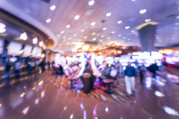 Typical gambling abstract background. Blurred slot machines, themed game, roulette slot poker 777, armed bandit with players at casino in Oklahoma. Colorful illuminated light on row of digital machine
