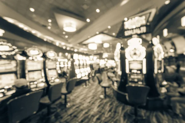 Vintage tone typical gambling abstract background. Blurred slot machines, themed game, roulette slot poker 777, armed bandit with players at casino in Oklahoma. Colorful illuminated light