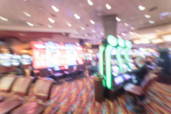 Typical gambling abstract background. Blurred slot machines, themed game, roulette slot poker 777, armed bandit with players at casino in Oklahoma. Colorful illuminated light on row of digital machine