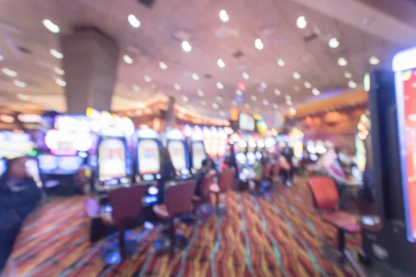 Typical gambling abstract background. Blurred slot machines, themed game, roulette slot poker 777, armed bandit with players at casino in Oklahoma. Colorful illuminated light on row of digital machine