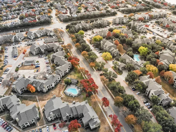 Top view apartment complex with swimming pool surrounded by colorful autumn leaves near Dallas, Texas, USA.