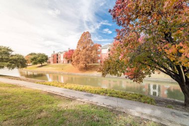 Nehir kenarında daire yansıması ile renkli sonbahar yaprakları banliyö Dallas, Texas, ABD bulut mavi gökyüzü altında satır. Bradford armut ve maple ağaçlar