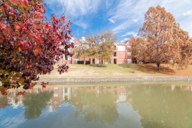 Nehir kenarında daire yansıması ile renkli sonbahar yaprakları banliyö Dallas, Texas, ABD bulut mavi gökyüzü altında satır. Bradford armut ve maple ağaçlar