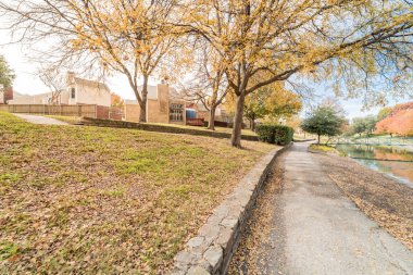Sonbahar mevsiminde Dallas, Texas, ABD banliyö bridge ile nehir townhouses renkli görünümü satırı. Bulut mavi gökyüzü altında parlak sonbahar yaprakları