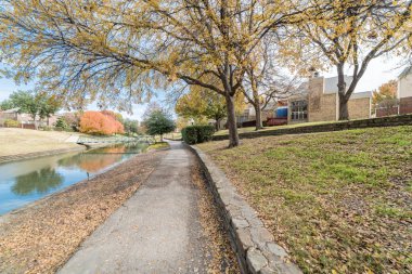 Sonbahar mevsiminde Dallas, Texas, ABD banliyö bridge ile nehir townhouses renkli görünümü satırı. Bulut mavi gökyüzü altında parlak sonbahar yaprakları